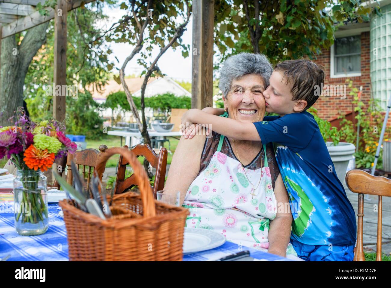 Junge, umarmen und küssen Großmutter Wange an Tomaten essen festival Stockfoto