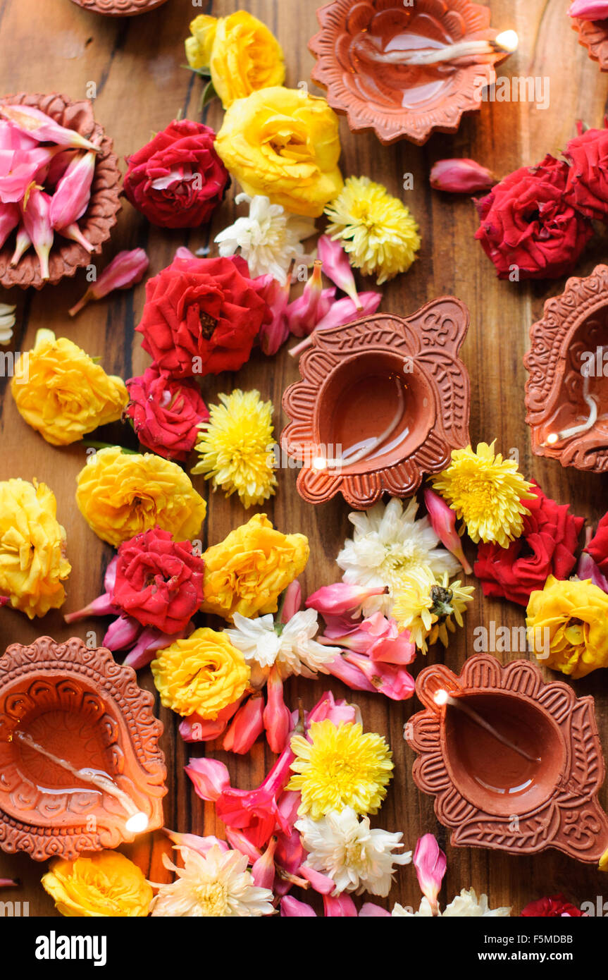 Diwali Diyas auf einem hölzernen Hintergrund mit festlichen Blumen und Lichter Stockfoto