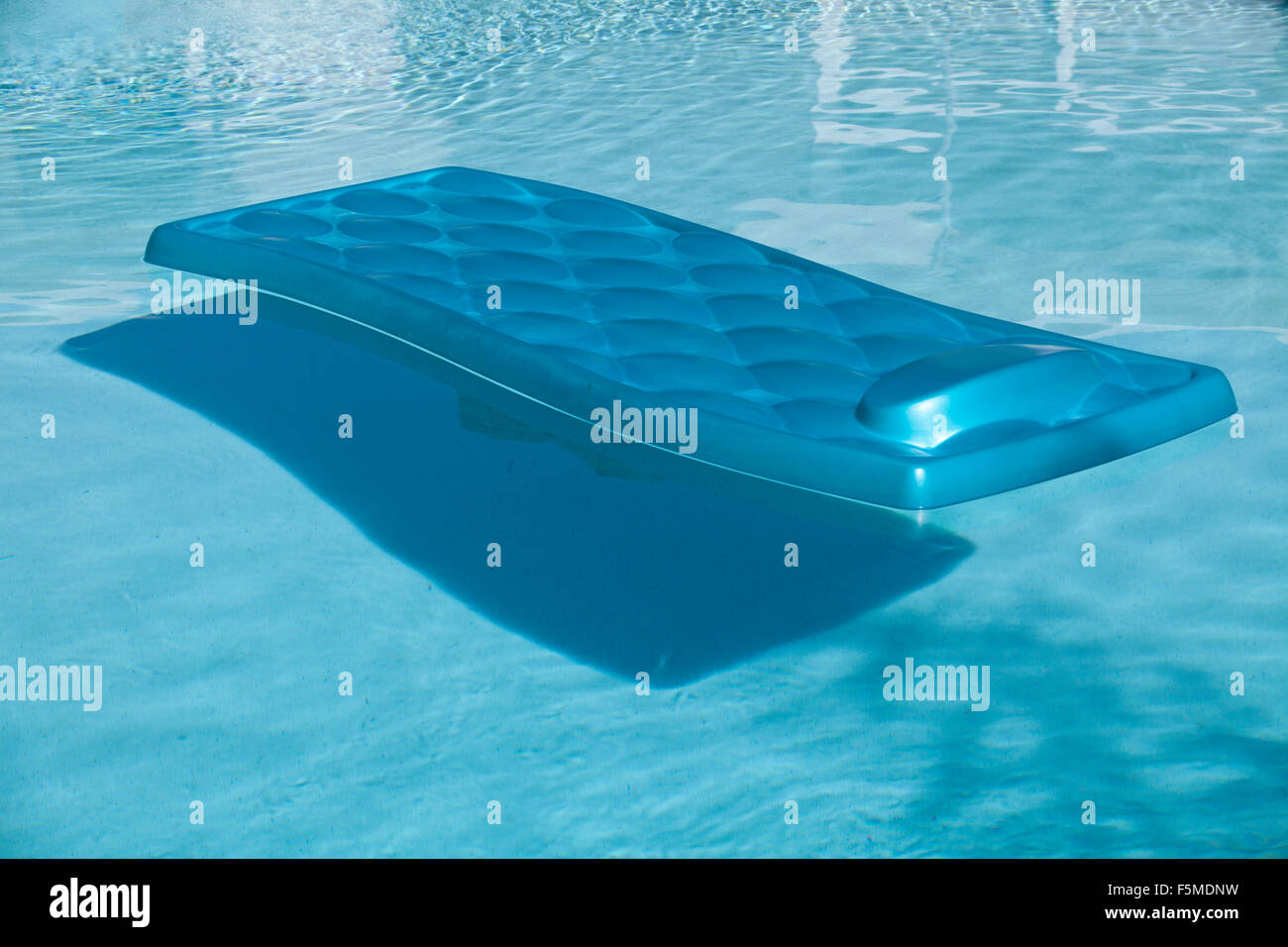 blaue Lilo auf Pool schwimmen Stockfoto
