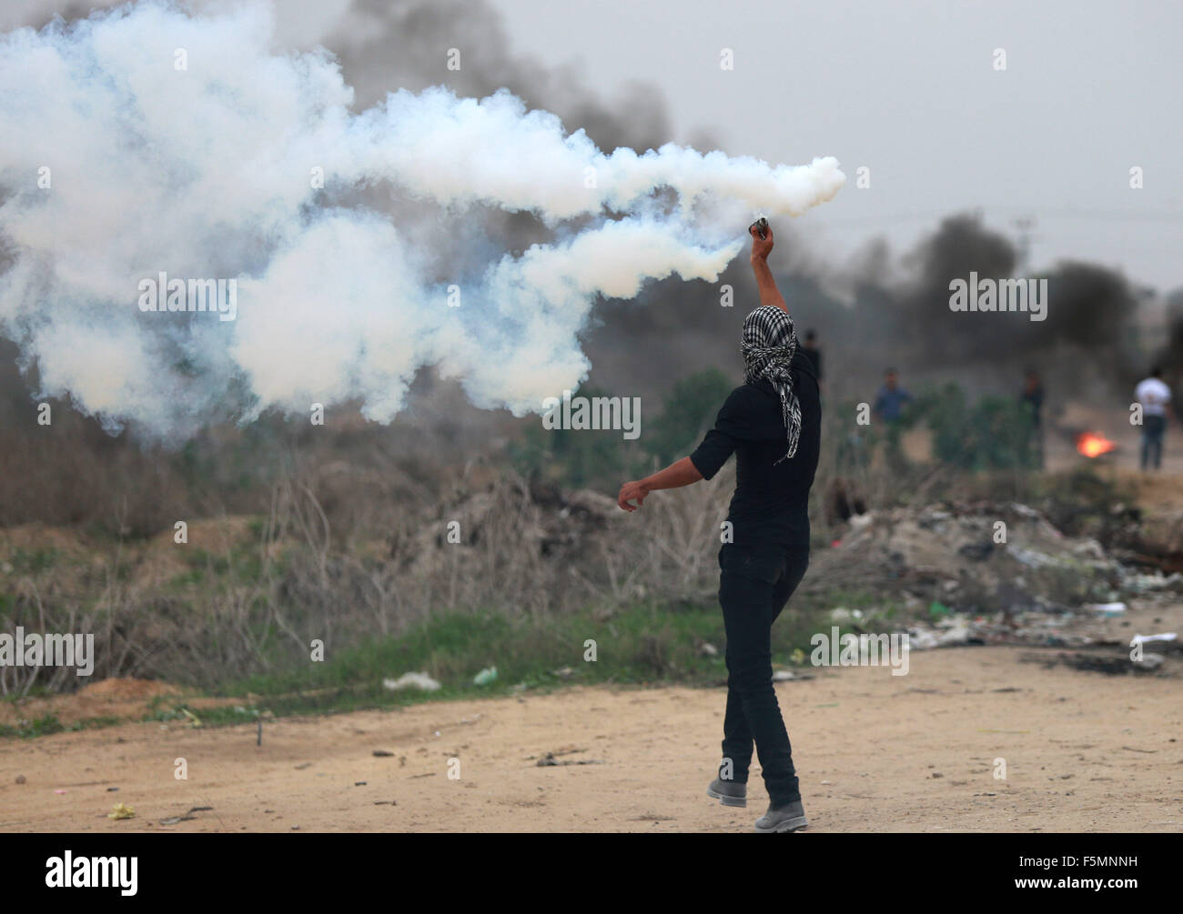 Gaza, Gaza-Stadt. 6. November 2015. Ein palästinensischer Demonstrant wirft zurück Kanister Tränengas abgefeuert von israelischen Soldaten in der Nähe der Grenze zwischen Israel und Gaza-Streifen, östlich von Gaza-Stadt, am 6. November 2015. Israelische Kräfte Schuss und getötet, einen Palästinenser im Gaza-Streifen bei Zusammenstößen entlang der Grenze, palästinensische Gesundheitsministeriums sagte. © Yasser Qudih/Xinhua/Alamy Live-Nachrichten Stockfoto