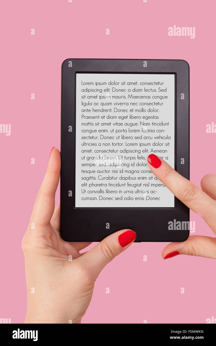 Weibliche Hand hält e-Reader auf rosa Hintergrund isoliert. Lesung, Bildung und Lernkonzept. Stockfoto