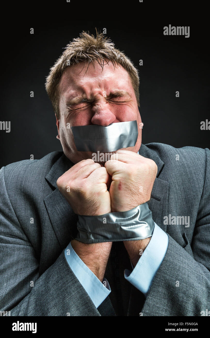 Mann mit Mund und Händen fallenden Klebeband verhindert Rede, Studio-Shooting Stockfoto