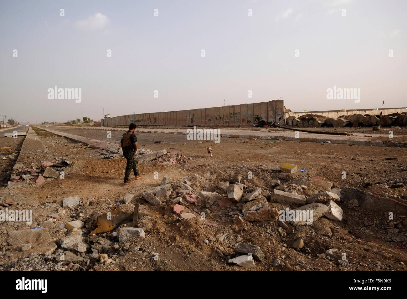 Ein kurdischer Kämpfer geht durch Schutt, der durch heftige Kämpfe verursacht wird Zwischen IS-Aktivisten und kurdischen Kämpfern in Rabia am Grenzübergang Zwischen Syrien und dem Irak in der Nähe der Stadt Al-Yarubiyah in Syrien Stockfoto