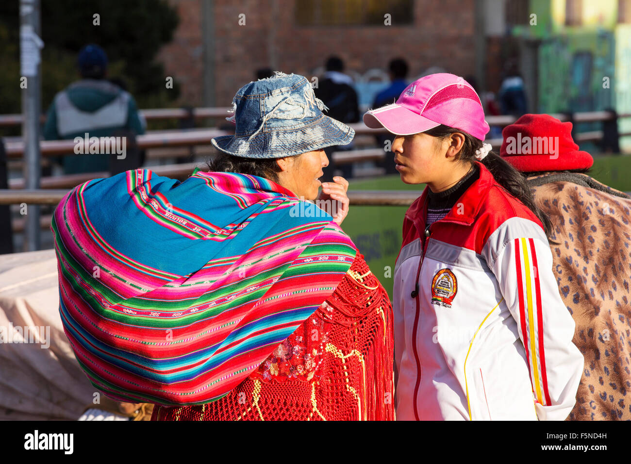 Eine einheimische Frau und Tochter auf einem Straßenmarkt in El Alto, La Paz, Bolivien, Südamerika, zeigen die traditionellen und modernen Möglichkeiten des Verbandes Stockfoto