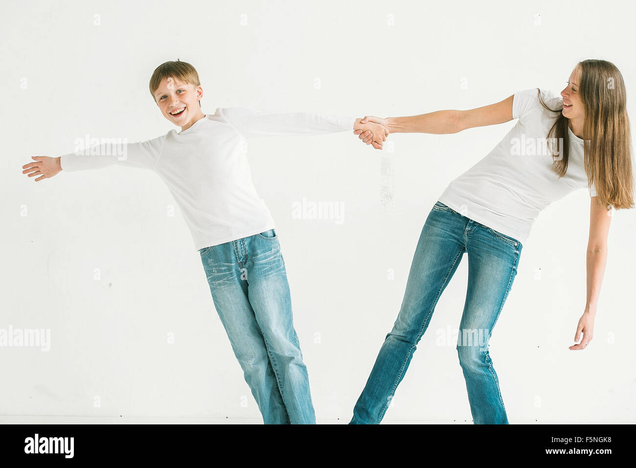 Familie Mutter mit Sohn spielt Studio Portrait in voller Länge in Jeans auf weißem Hintergrund Stockfoto