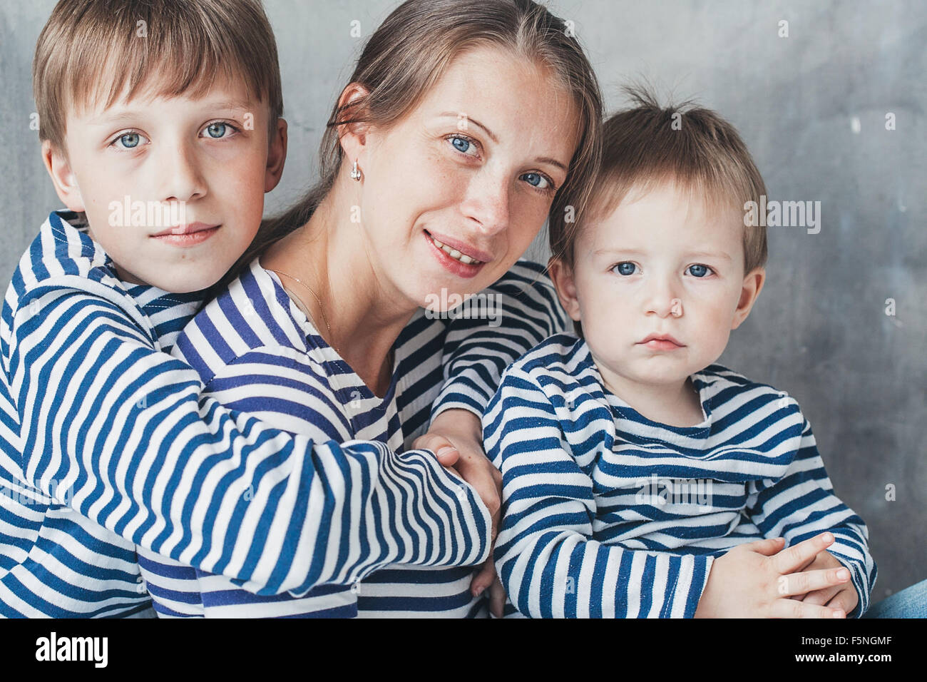 Mutter mit Kindern glücklich zusammen Studioportrait auf grauem Hintergrund Stockfoto