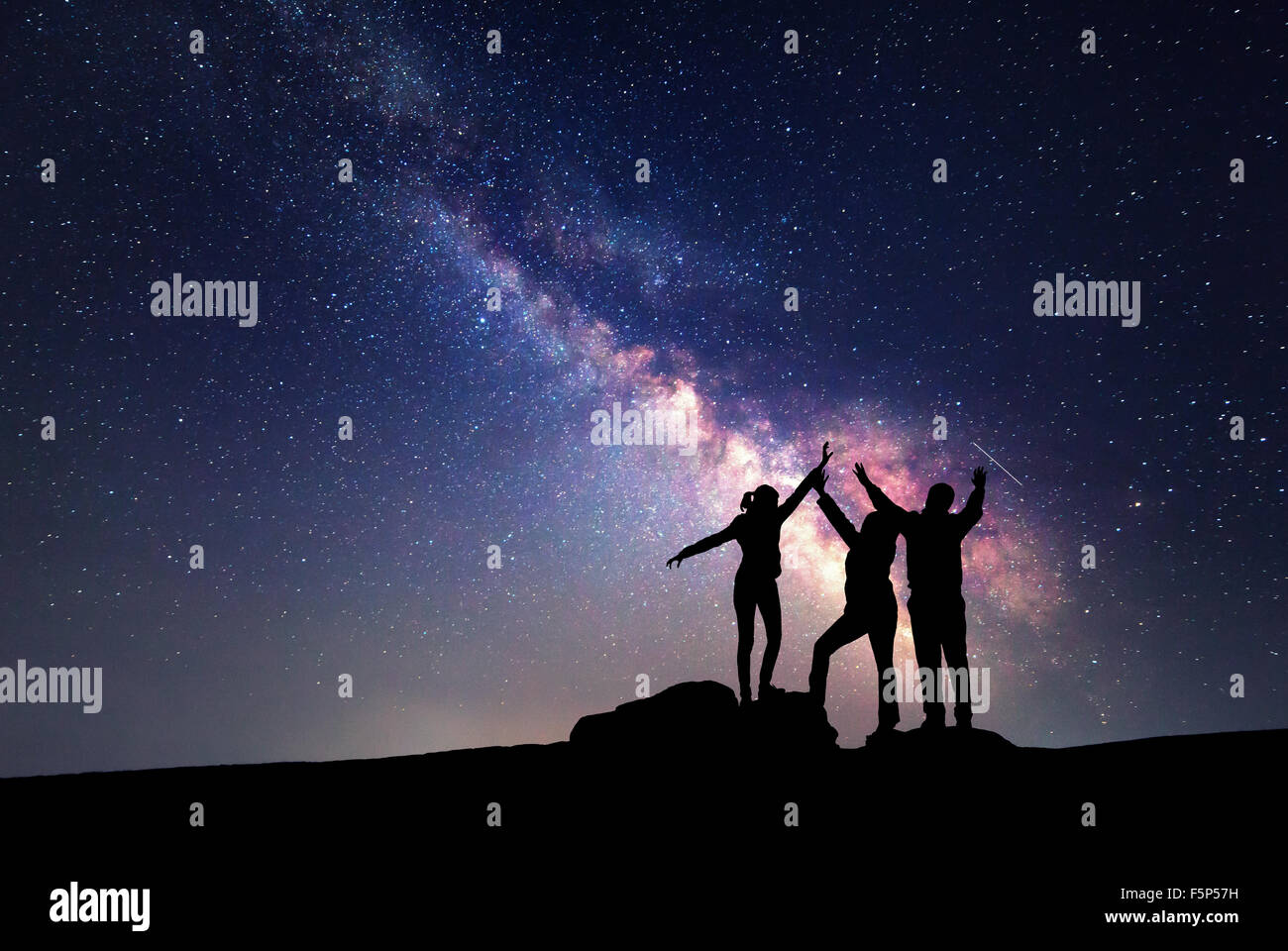 Milky Way. Nachthimmel mit Sternen und Silhouette einer glücklichen Familie aufgewachsen bis Arme Stockfoto