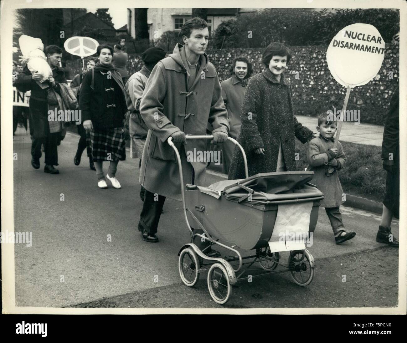 1954 - Bomb-Kampagnen weiterhin ihre 45-Meile Trek zu Armstrong unter winterlichen Bedingungen. Nach einem Aufenthalt in Maidenhead über Nacht, die 600 '' Ben die Bombe '' Demonstranten, alles, was bleibt von 5000, die angefangen vom Trafalgar Square am Karfreitag, setzte heute ihre 45-Meile Protestmarsch auf die nächste Stufe ihrer Reise zu lesen. Sie sollen ihr Ziel zu erforschen, die Atomwaffen Forschung Einrichtung., im Stadtrat, Berkshire, am Montag. Foto zeigt, wie Vater seine junge Baby im Kinderwagen, ging seine Frau schiebt neben mit ihrem kleinen Sohn, der einen Banner trägt wenn sie startete Stockfoto