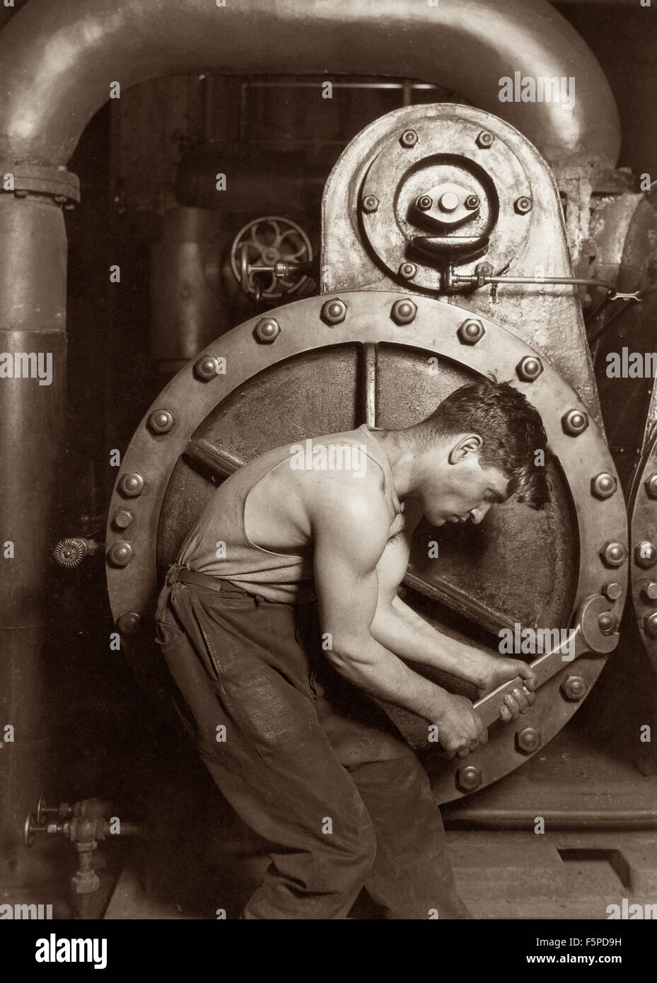 Classic 1920 Foto von Lewis Wickes Hine eines macht-Haus-Mechaniker arbeiten auf eine Dampfpumpe. Stockfoto