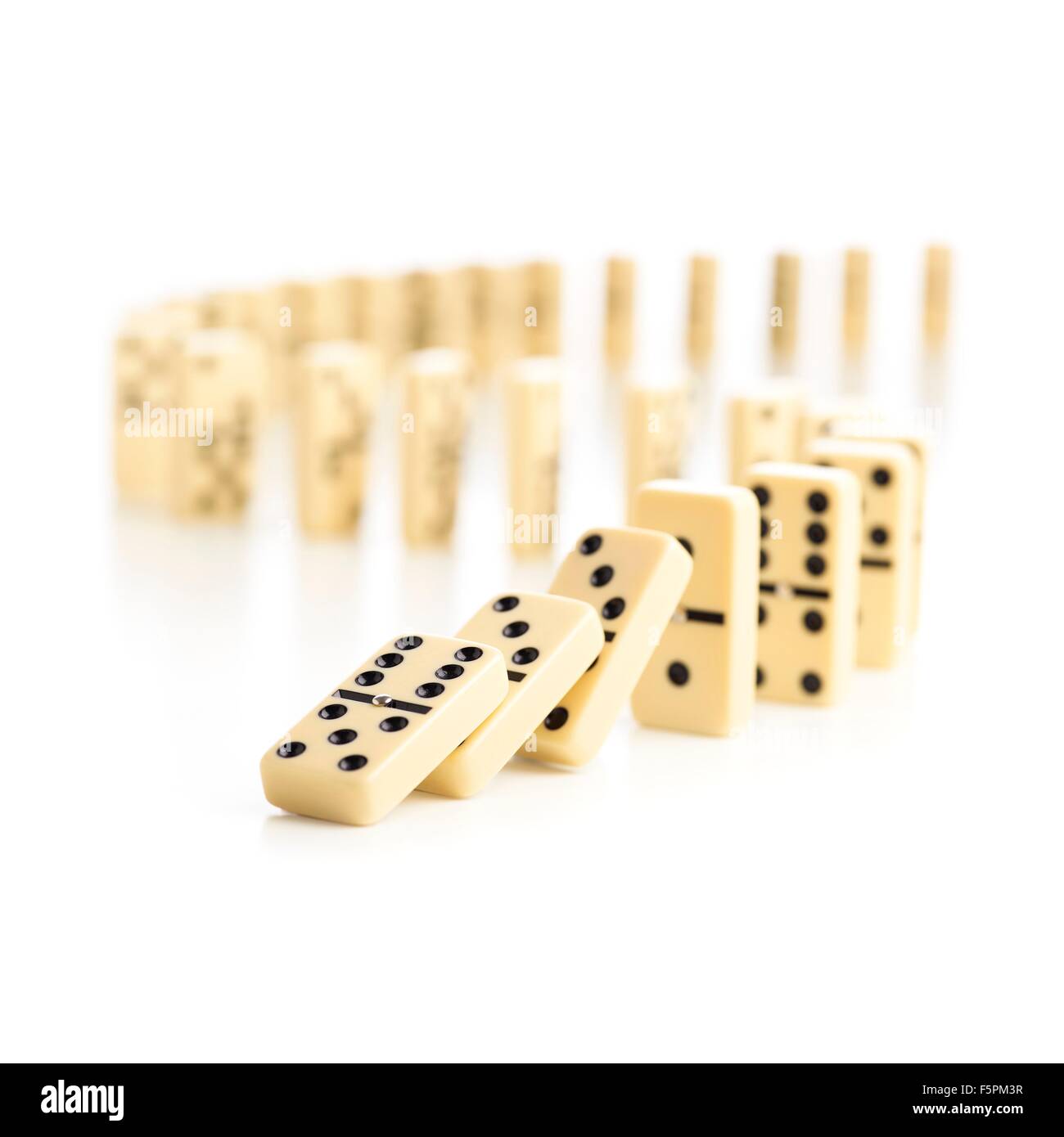 Dominosteine fallen vor einem weißen Hintergrund. Stockfoto