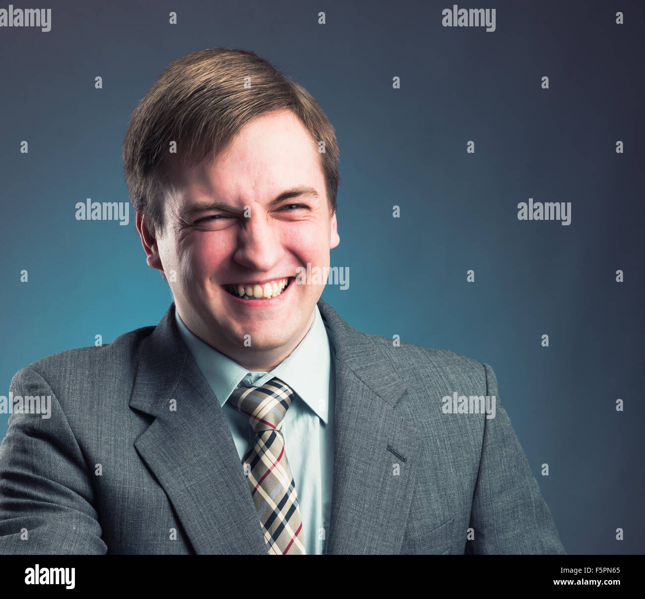 Lächelnde Geschäftsmann auf grauem Hintergrund isoliert Stockfoto