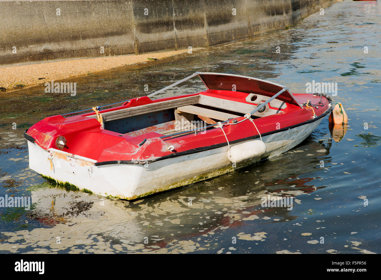Sad suchen Schnellboot, klar etwas renovierungsbedürftig. Rote und weiße Boot nur knapp über Wasser im trüben Wasser Stockfoto
