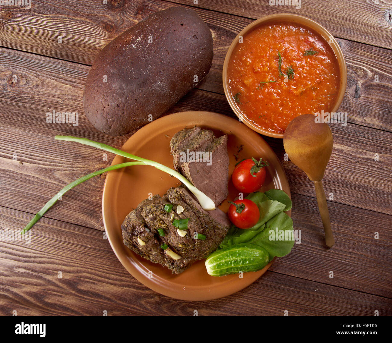 Italienische rustikales Abendessen - Tomatensuppe oder Pappa al Pomodoro und gebratenes Rindfleisch und Gemüse mit Brot, Farm-Stil Stockfoto