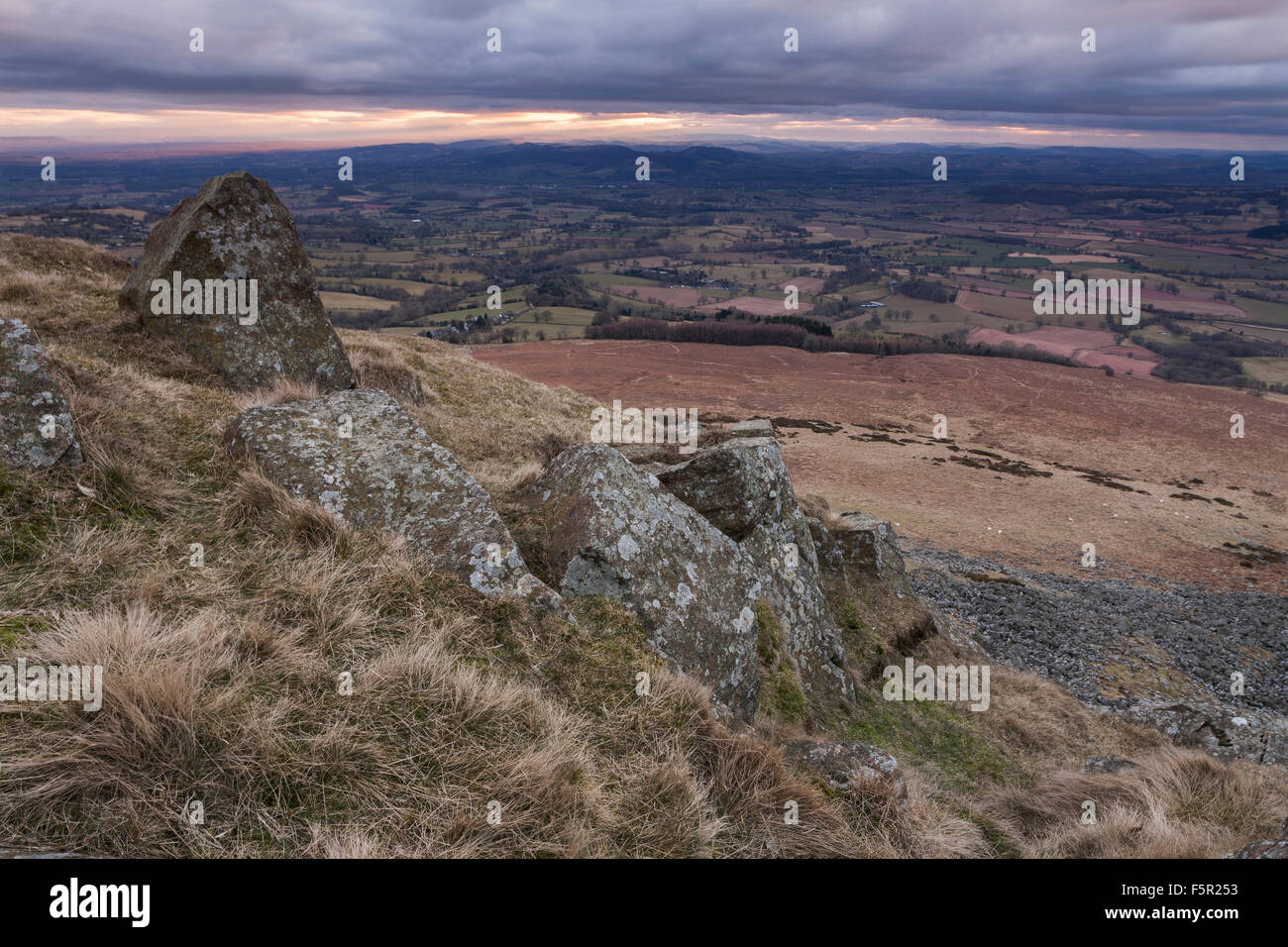 Felsen am Titterstone Clee Hügel, mit Blick auf die Felder von Shropshire, England bei Sonnenuntergang Stockfoto