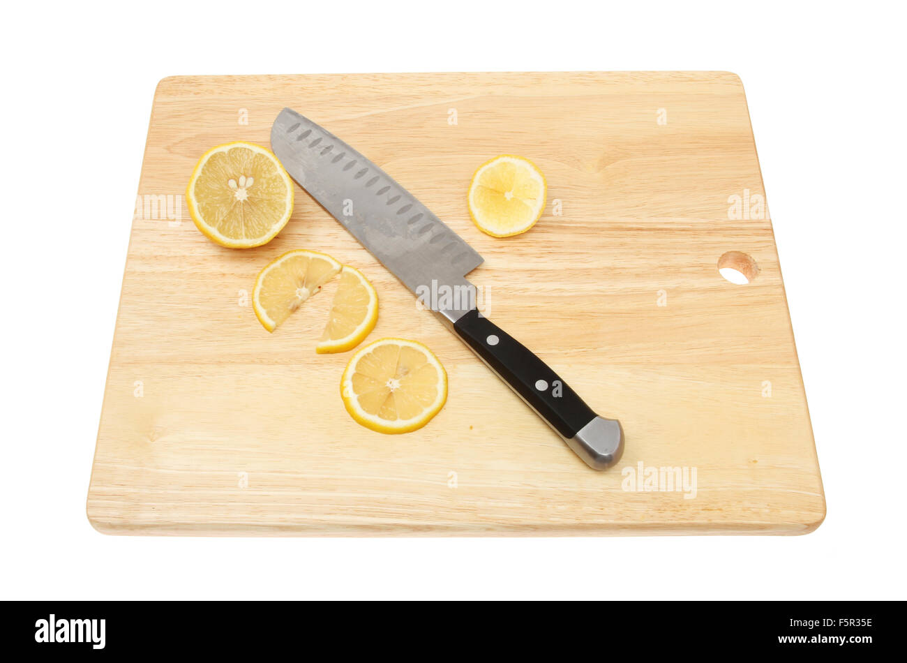 Geschnittene Zitrone und ein Messer auf ein Schneidbrett aus Holz isoliert gegen weiß Stockfoto