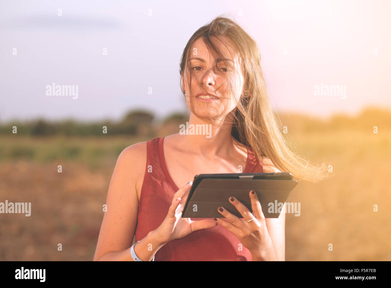 Junge kaukasischen Brünette Frau mit Tablet im Land warm Filter angewendet Stockfoto