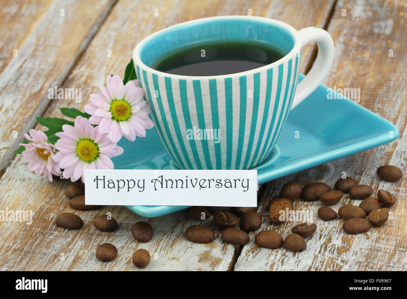 Glücklich Geburtstag Karte mit Tasse Kaffee und rosa Gänseblümchen auf rustikalen Holzoberfläche Stockfoto