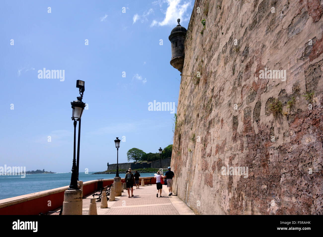 Touristen zu Fuß auf dem Gehweg unter der Stadtmauer, Paseo del Morro, Old San Juan, Puerto Rico-Karibik Stockfoto