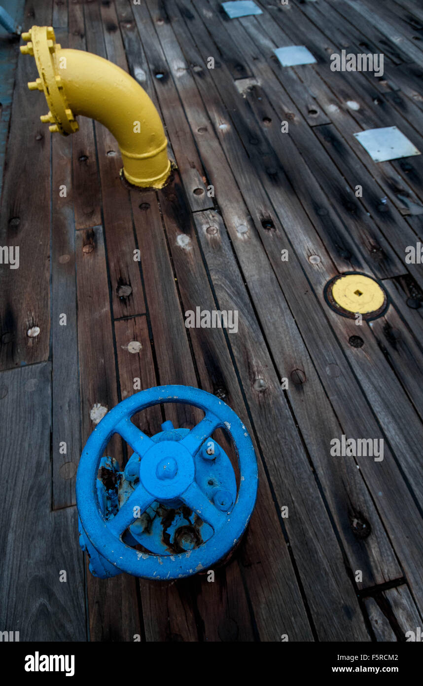 Ein blaues Ventil und eine gelbe Leitung auf dem Deck ein Schlachtschiff. Stockfoto