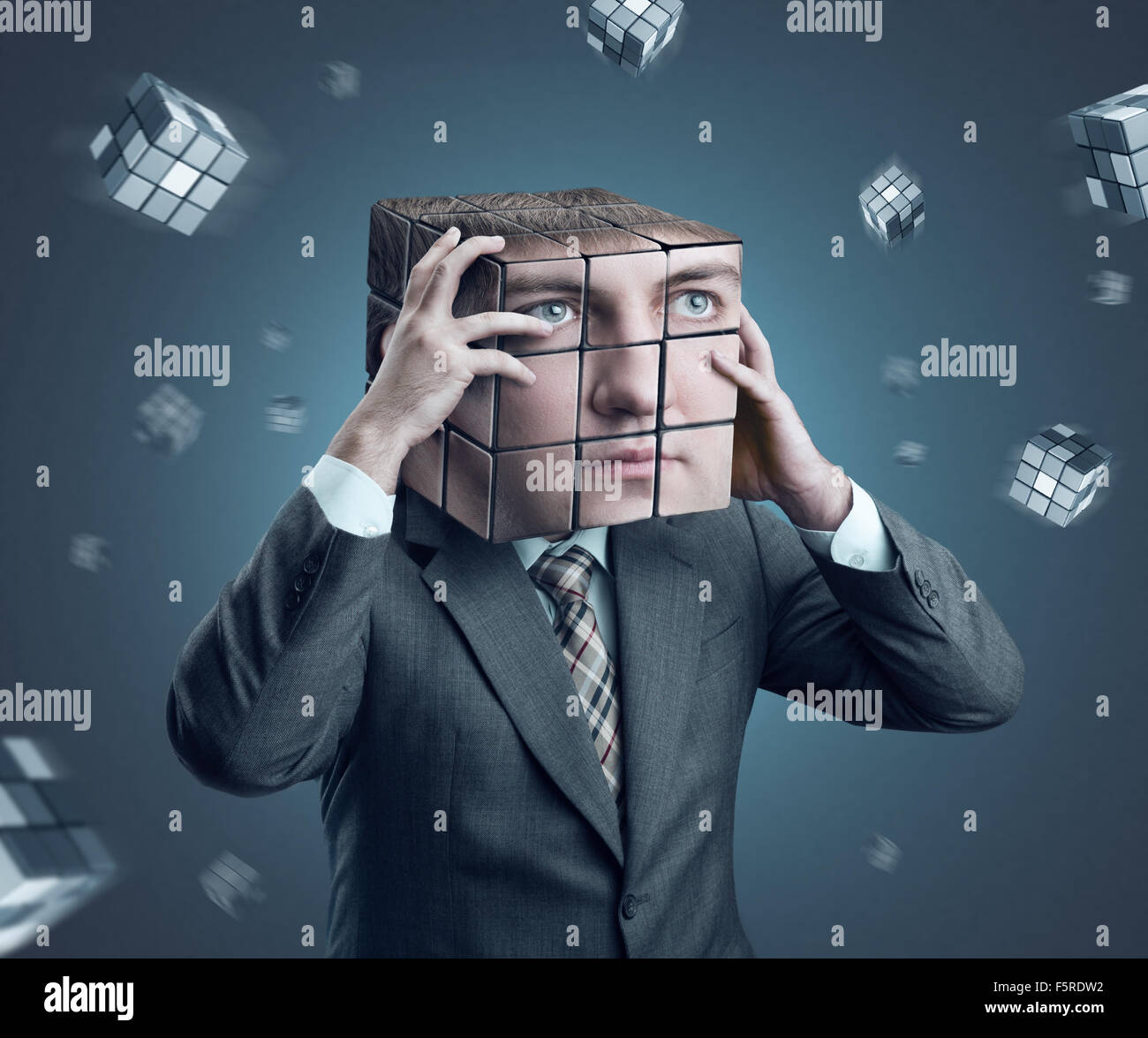 Geschäftsmann hielt seinen Kopf Rubik cube Stockfoto