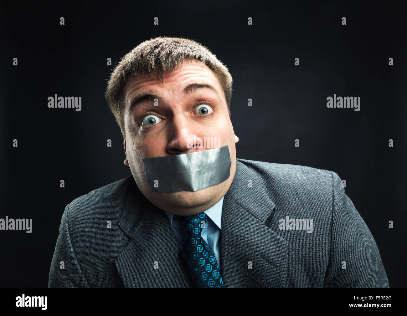 Überrascht Man mit Mund fallenden Klebeband verhindert Rede, Studio-Shooting Stockfoto