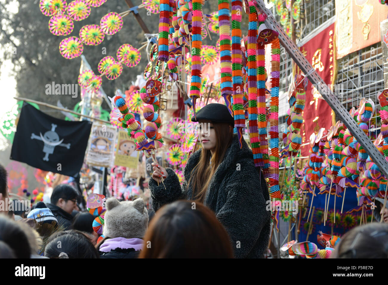 junges Mädchen Verkäufer halten bunte Spielsachen zum Verkauf auf Ditan Temple Fair Chinesisches Neujahr Frühlingsfest Stockfoto