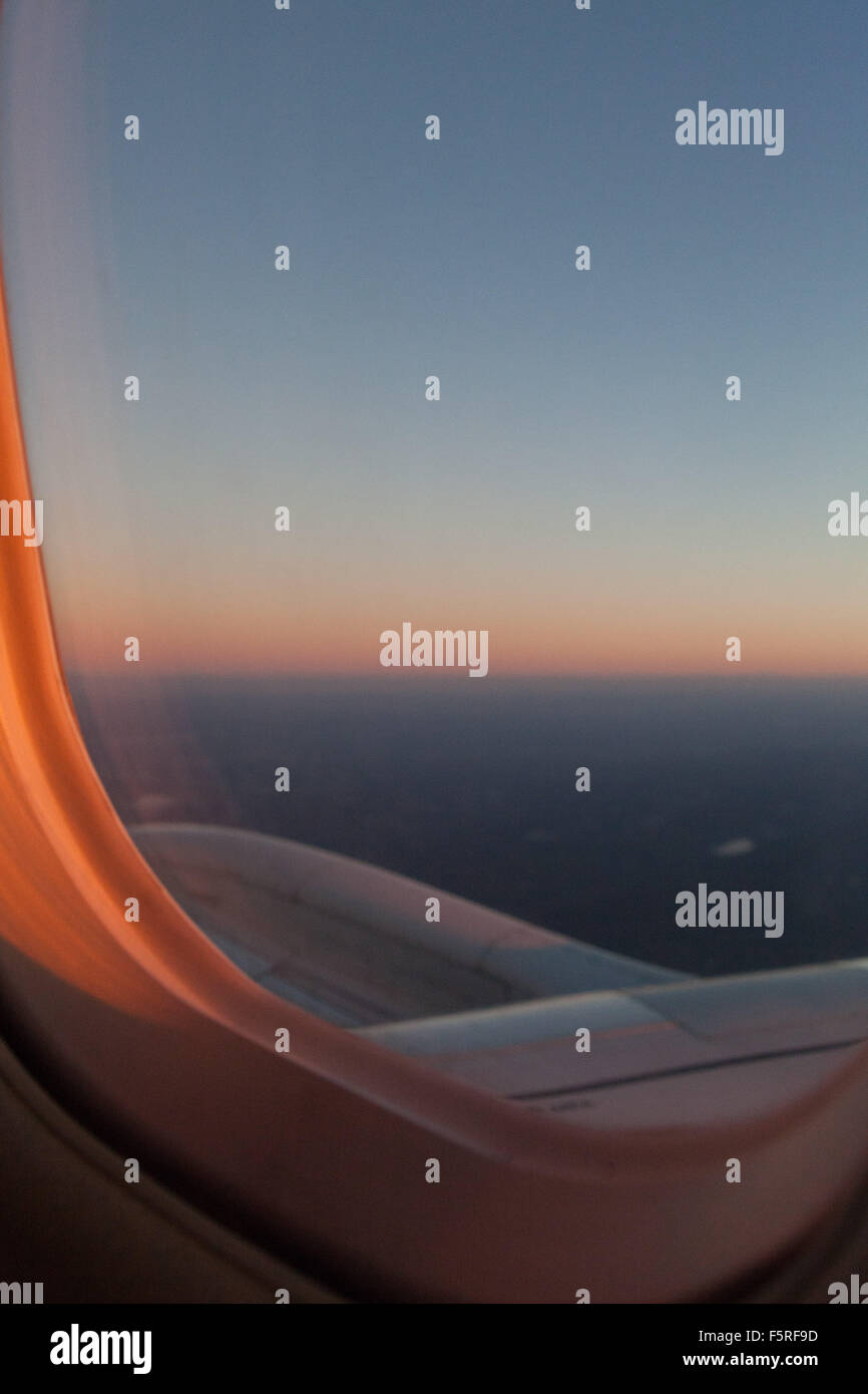 Sonnenaufgang verlassen wir New York City, die Flügel des Flugzeugs, die Landschaft unter gefärbt mit dem Licht des Sonnenaufgangs. Stockfoto