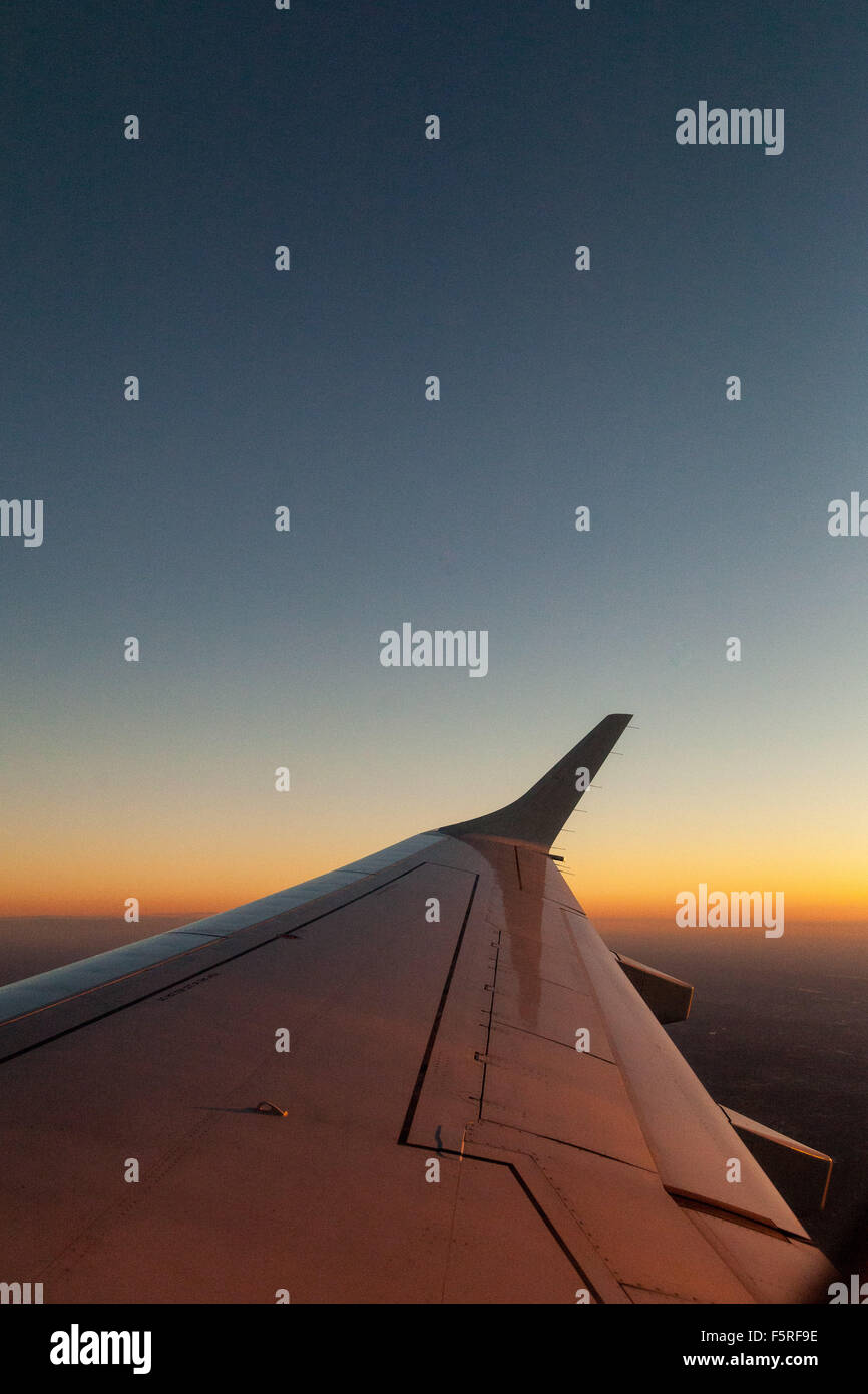 Sonnenaufgang verlassen wir NYC, erhebt sich die Flügel des Flugzeugs über den Sonnenaufgang. Stockfoto