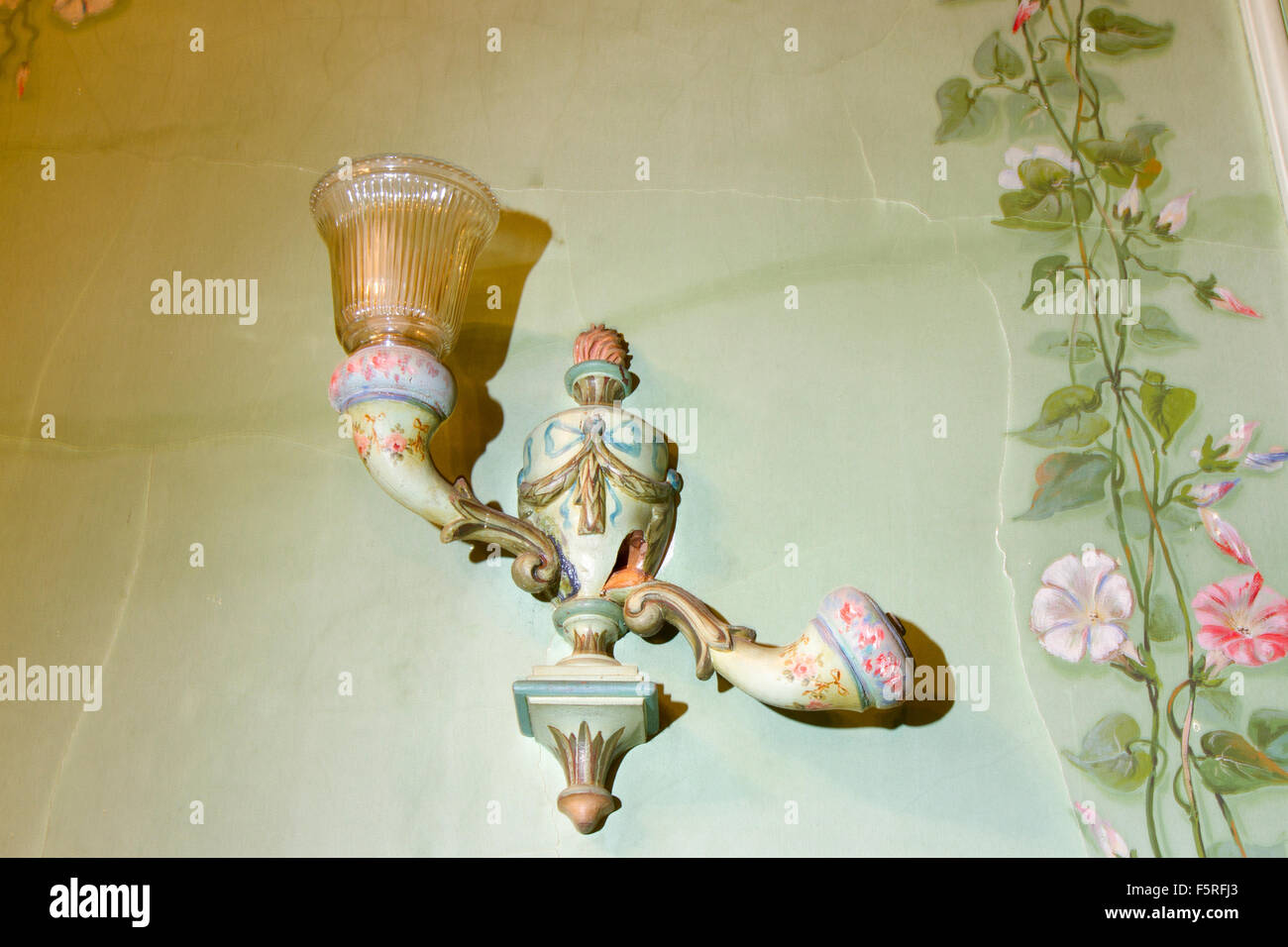 Antike Beleuchtung Wandleuchte auf grün bemalten Tapete. Stockfoto