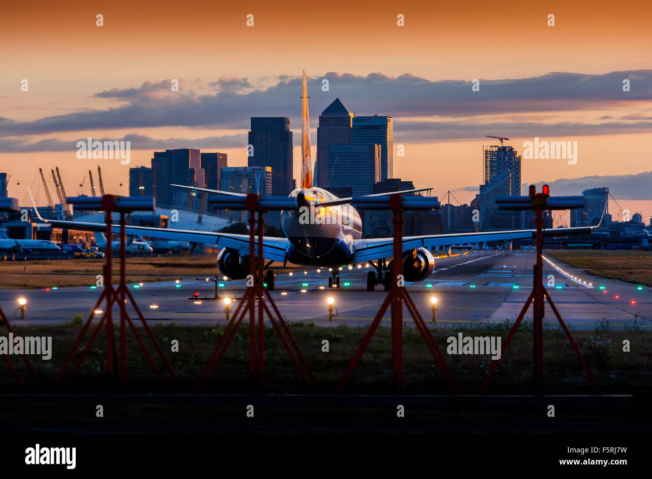 Ein Passagierjet Flugzeug warten auf die Start-und Landebahn am Flughafen London City Airport Stockfoto