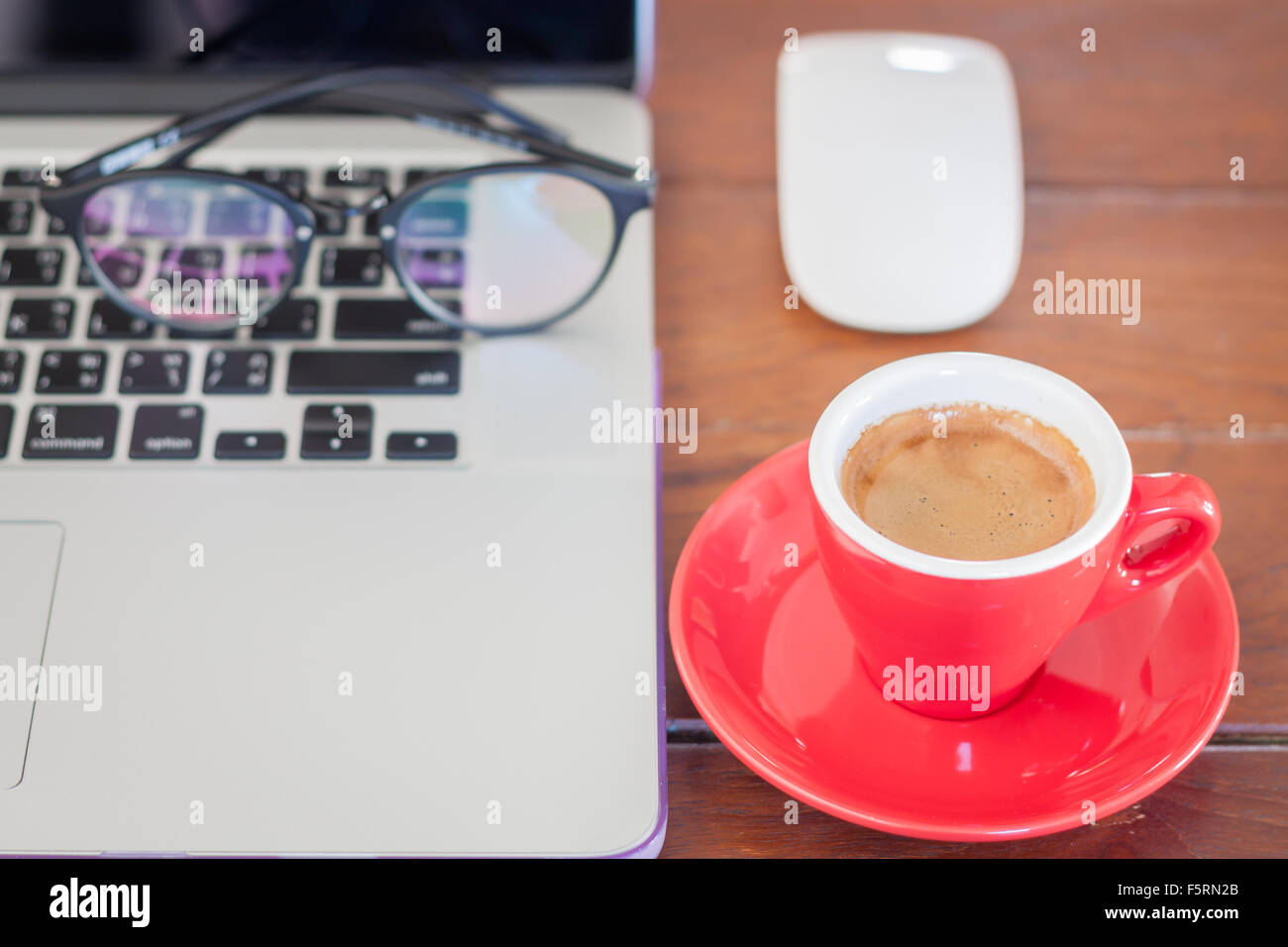 Rote Kaffeetasse auf Arbeitsplatz, Fotoarchiv Stockfoto