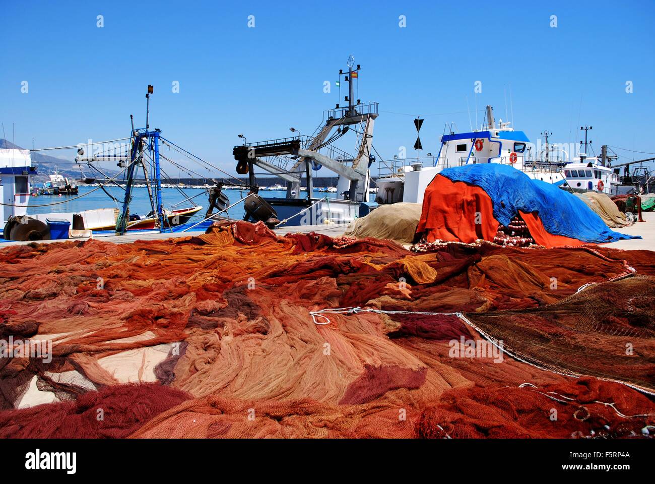 Fischernetze ausgebreitet auf dem Boden trocknen in der Sonne im Fischerhafen, Fuengirola, Provinz Malaga, Andalusien, Spanien. Stockfoto