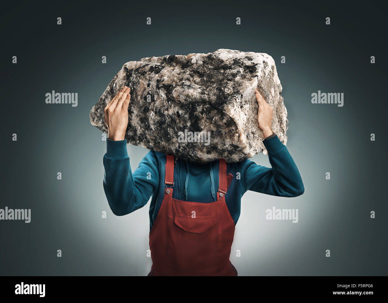 Mann mit einer großen Felsen Insread des Kopfes Stockfoto