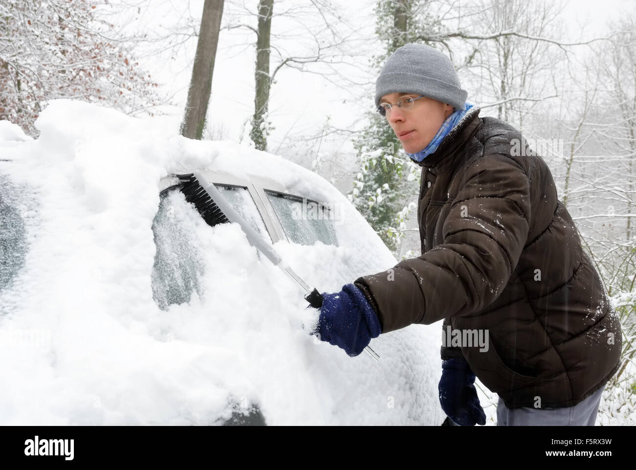Der junge Mann reinigt im Winter die Front- und Seitenscheiben des Autos  vom Schnee mit einer gelben Bürste., Stockvideos - Envato Elements