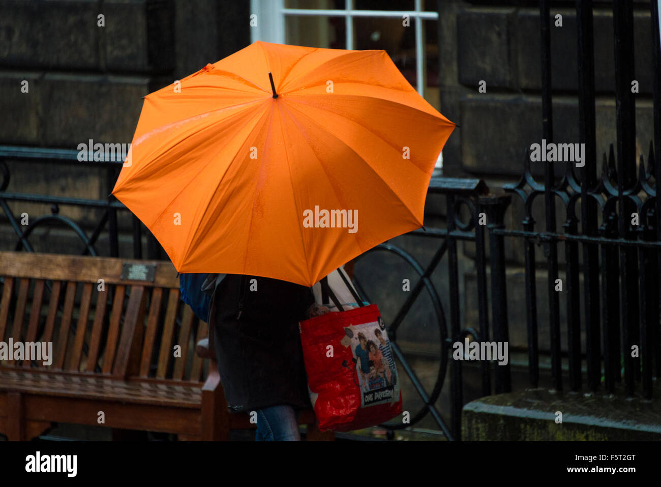 Edinburgh, Schottland. 9. November 2015. Montag 9. November 2015: Wetter - Edinburgh. Ein Fußgänger mit einem hellen orange Schirm auf der Royal Mile in Edinburgh heute Morgen. Orkanartigen Winden werden erwartet, um Großbritannien heute schlagen die sehen konnte die erste Benennung eines Sturms unter dem neuen System. Wenn das Wetter schwerwiegend, ist wie Meteorologen vorhersagen und trifft Kriterien Sturm dann das Met Office offiziell es Sturm Abigail Credit nennen wird: Andrew O'Brien/Alamy Live News Stockfoto