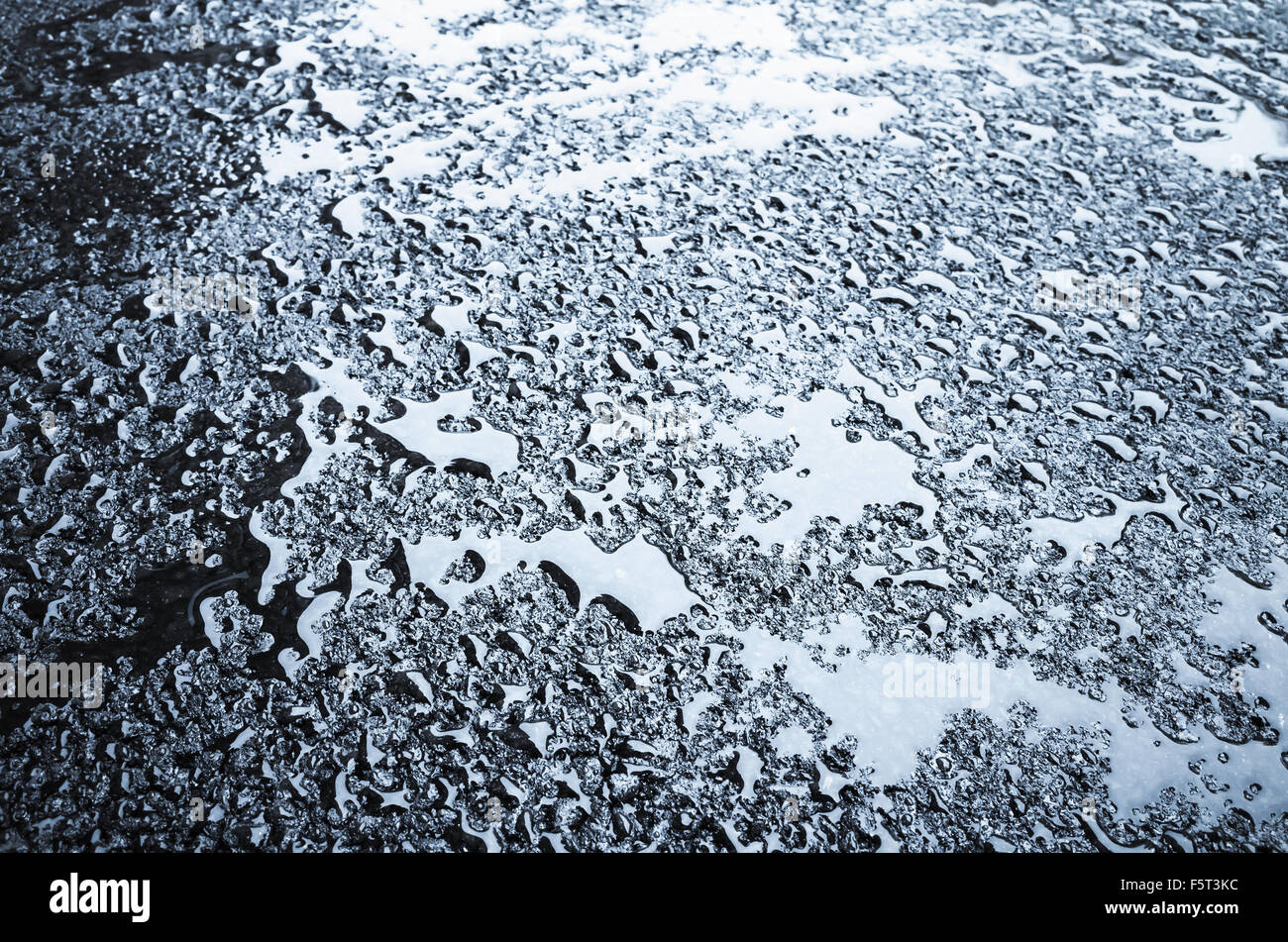 Wassertropfen auf nassen dunklen Asphalt, blau getönten Transport Hintergrundtextur Stockfoto