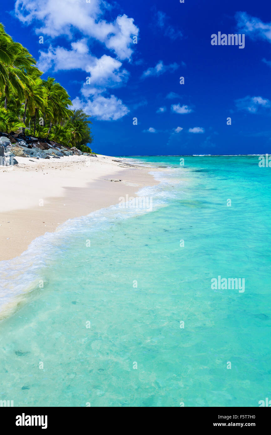 Tropischer Strand mit Felsen und Palmen auf Rarotonga, Cook-Inseln Stockfoto