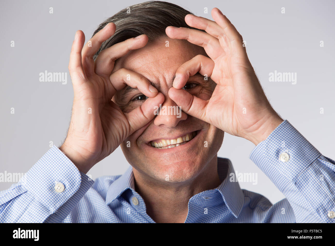 Studioaufnahme des Mannes Spektakel Form mit seinen Händen Stockfoto
