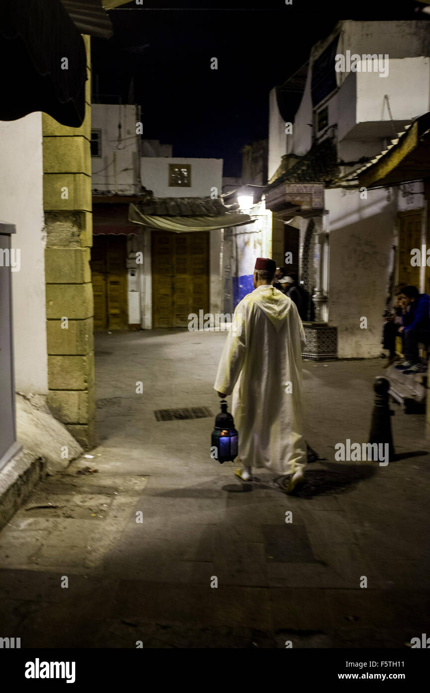 Mann in traditionellen Kostümen mit einer Laterne in der Medina in der Nacht, Rabat, Marokko Stockfoto