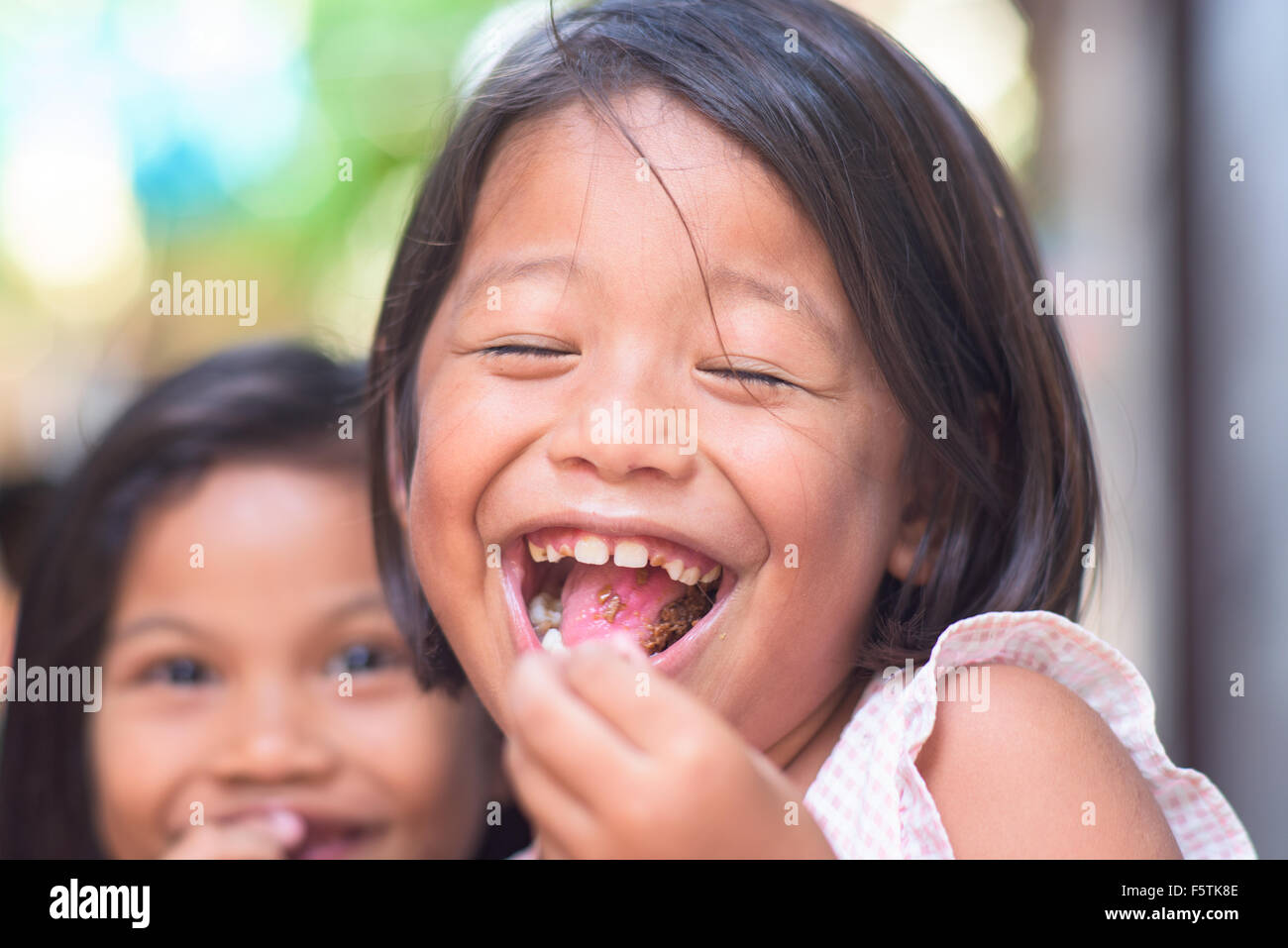Philippinische Mädchen Lächeln während des Essens Süßigkeiten. Stockfoto
