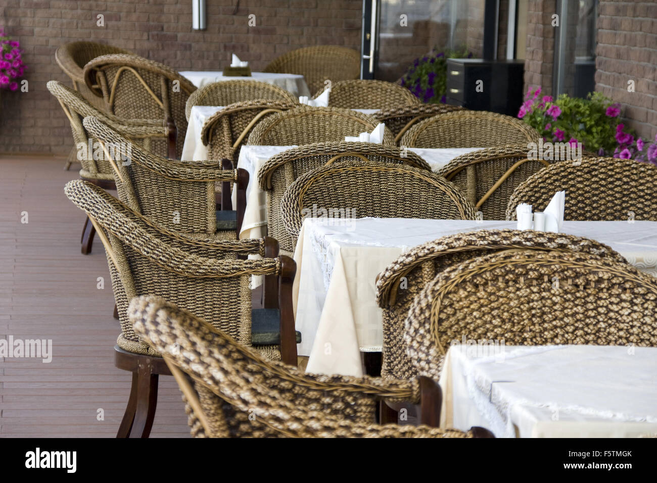 Café im Freien. Reihe von Rattanstühle und Tische Stockfoto