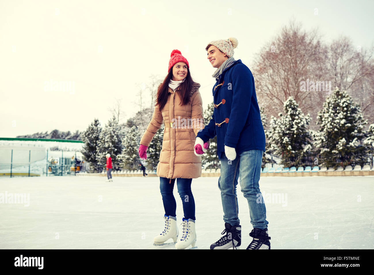 glückliches Paar Eislaufen am Eislaufplatz im freien Stockfoto