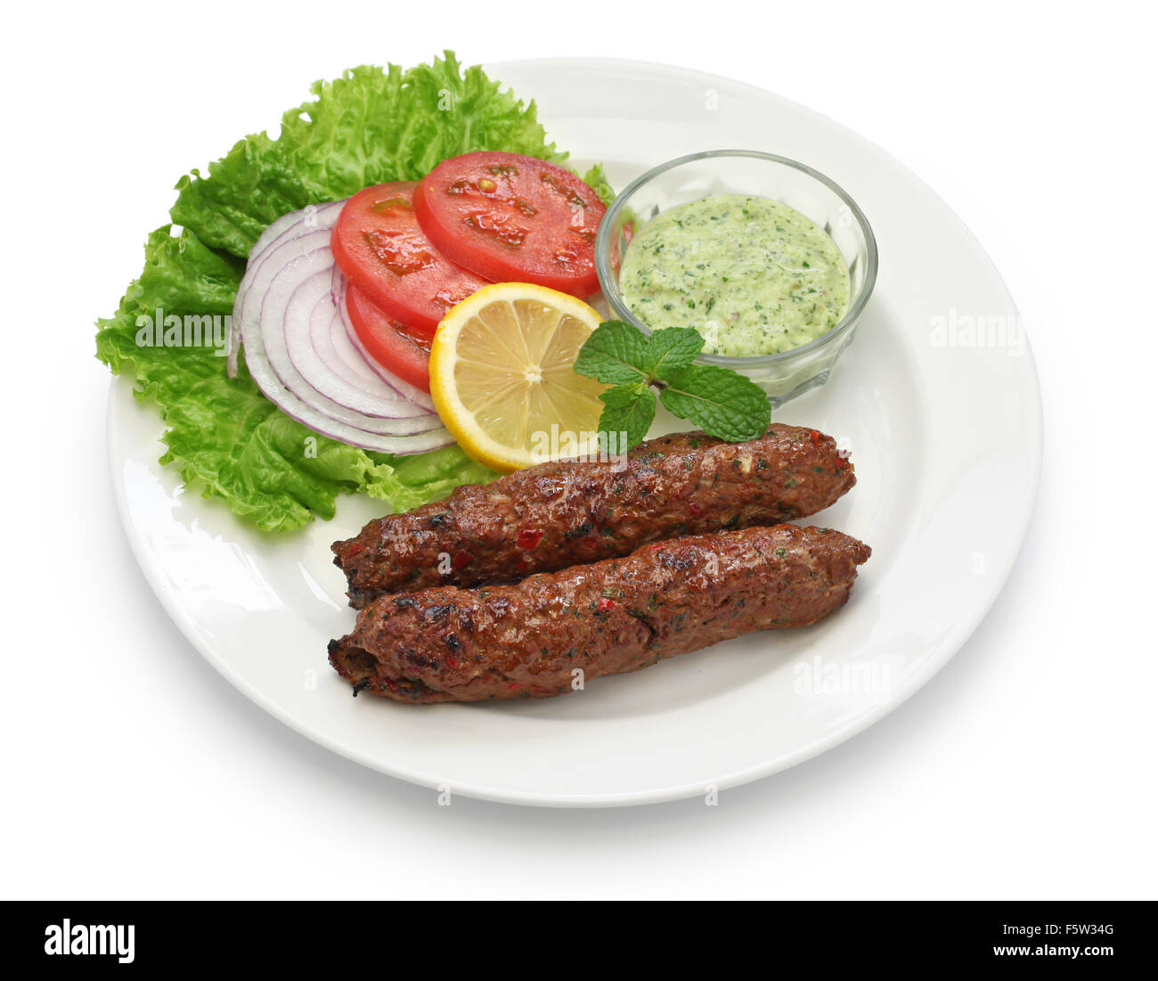 Mutton Seekh Kabab mit Minze-Chutney isoliert auf weißem Hintergrund Stockfoto