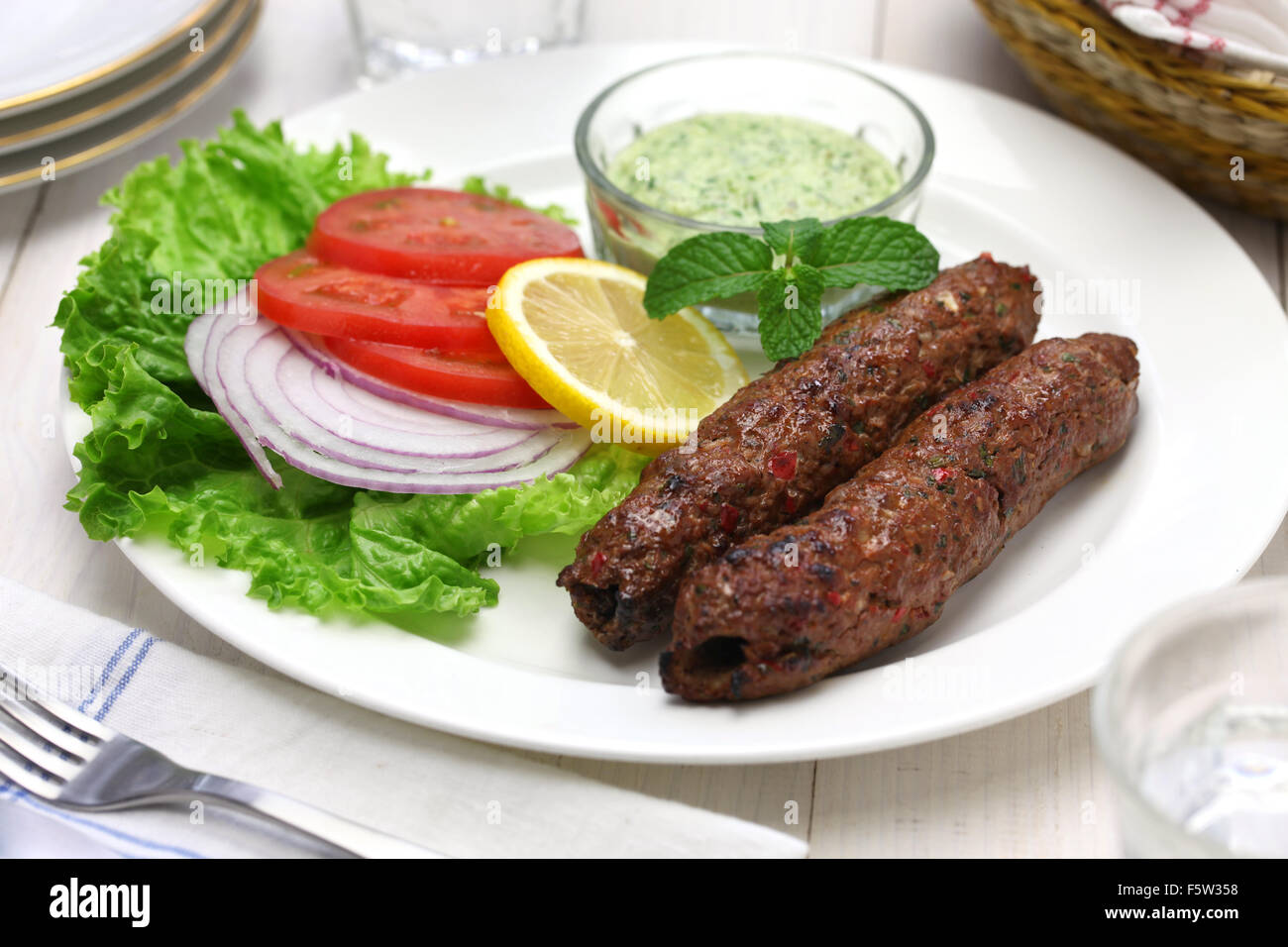 Mutton Seekh Kabab mit Minze-Chutney isoliert auf weißem Hintergrund Stockfoto