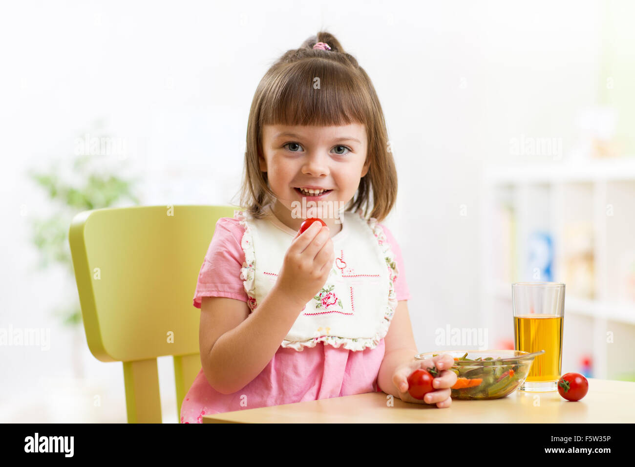 Kind Mädchen essen Gemüsesalat in Haus Stockfoto