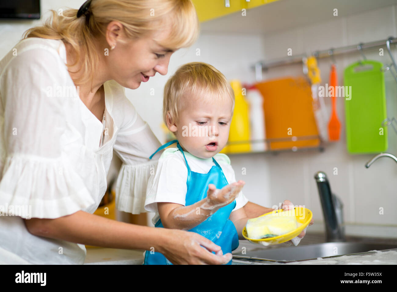 Mutter und Sohn Reinigung Geschirr zusammen Stockfoto