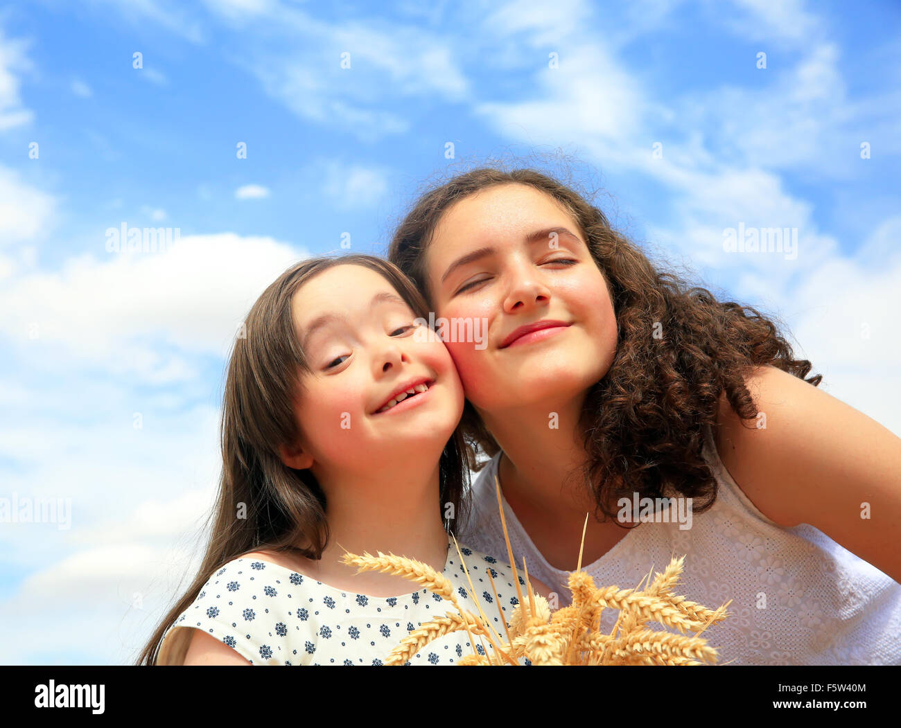 Glückliche Momente mit der Familie - junge Mädchen, die Spaß ln Weizenfeld Stockfoto