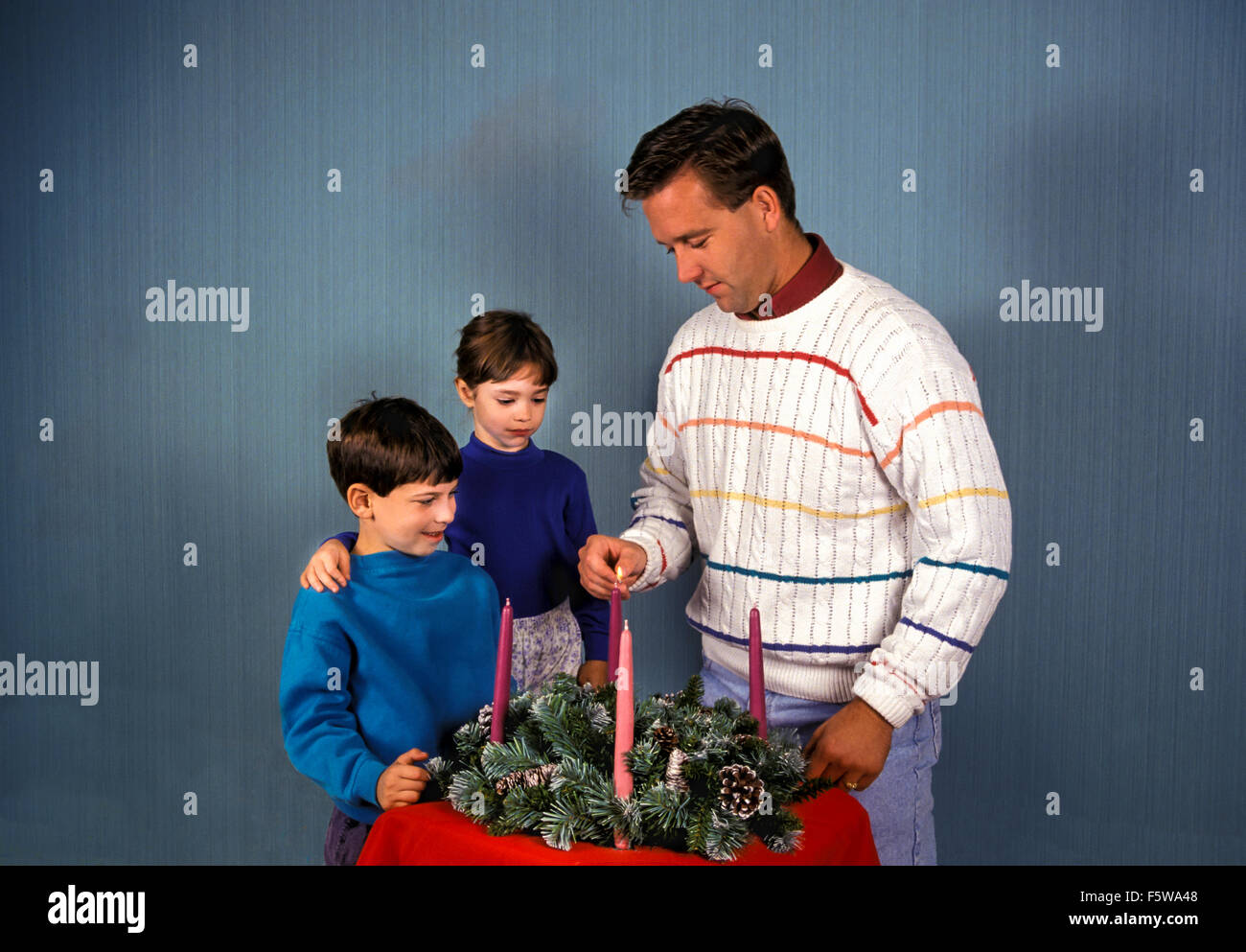 Vater Lichter Advent Kerze in Kranz als Sohn und Tochter stand neben ihm. Ausschnitt.  Herr © Myrleen Pearson Stockfoto