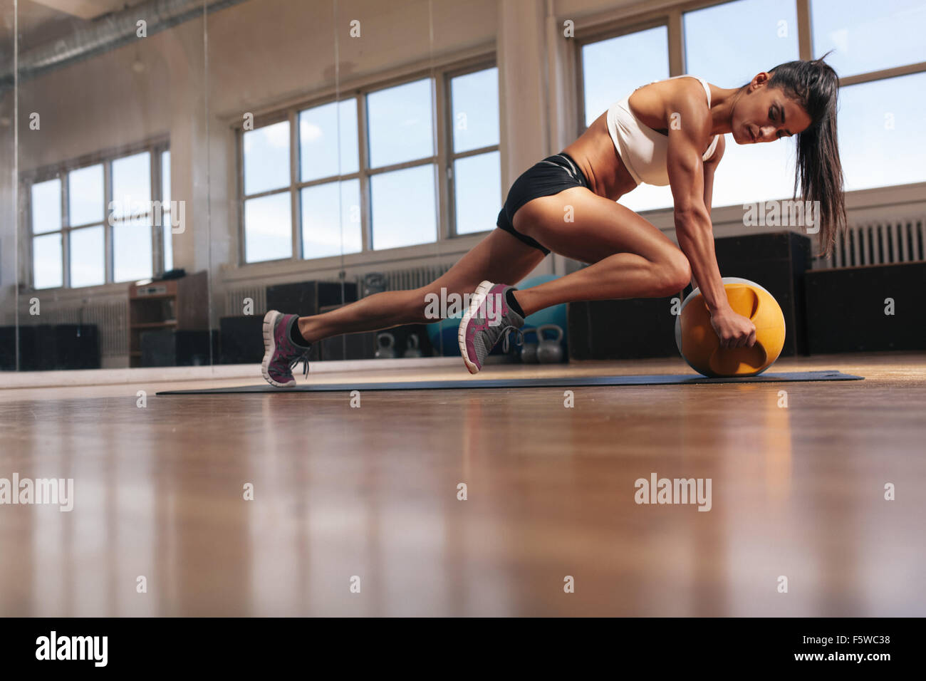 Frau dabei intensive Kern Übung auf Fitness-Matte. Muskulöse junge Frau Training im Fitness-Studio zu tun. Stockfoto