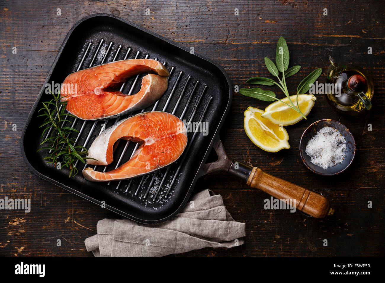 Roher Lachs Steak auf dem Grill Pfanne auf hölzernen Hintergrund mit Würze Stockfoto
